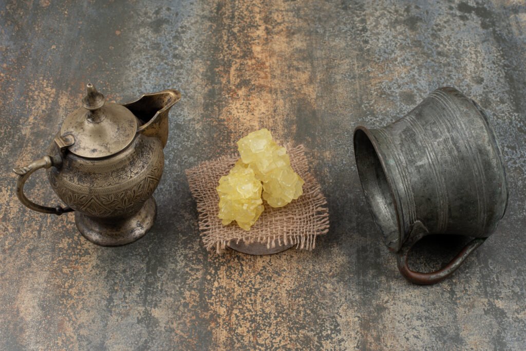 Two ancient kettles with slices of sweet sugar on marble background. High quality photo